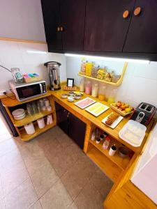 门多萨Mora Hostel的厨房配有带食品的柜台和微波炉