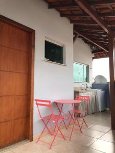 巴巴塞纳Sinta-se em casa.的厨房里配有两张红色的椅子和一张桌子