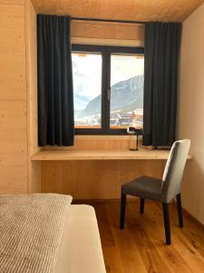 安泰塞尔瓦·迪·梅佐Chalet Bergfuchs的卧室设有窗户、椅子和书桌