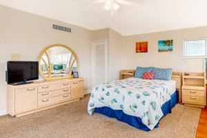 基克罗尼海滩Breezy Palms & Tropical Charm的一间卧室配有一张床和一台平面电视