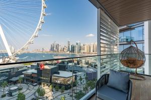 迪拜Bluewaters Luxe 3BR with maids room - Panoramic Sea View - CityApartmentStay的阳台享有伦敦眼(london eye)的景致。