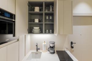 马德里Rio by Wynwood House的厨房配有白色橱柜和水槽