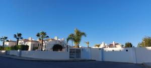 阿尔布费拉Baia Village - Praia do Castelo - Galé - Albufeira的棕榈树屋前的白色围栏