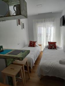 马拉加KHORS的客房设有两张床、一张桌子和一张桌子。