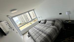拉塞雷纳Dpto en Resort Laguna del Mar frente al mar 2D2B的一间卧室设有一张床和一个大窗户
