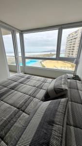 拉塞雷纳Dpto en Resort Laguna del Mar frente al mar 2D2B的一间卧室配有一张床,享有海滩美景