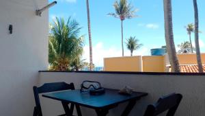 萨尔瓦多FAROL BEACH Suítes的一张带两把椅子的蓝色桌子和棕榈树