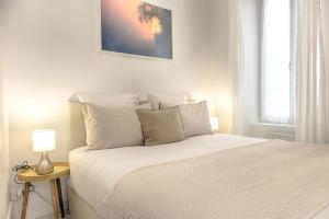 奥尔良Le Nid Cosy -Au Cœur d'Orléans的白色卧室配有一张带白色枕头的大床