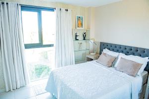普拉亚多Condominio Iberostate的一间卧室设有一张床和一个大窗户