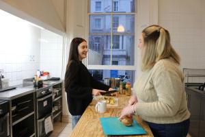 伦敦Urbany Hostel London 18-40 Years Old的两名妇女站在厨房里说话