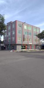 Puerto GaitánHOTEL CANAGUARO GAITAN的一座大型建筑,前面设有停车场