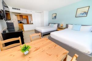 迈阿密海滩SeaStays Apartments的一间卧室配有一张床铺和一张桌子,另一间卧室配有一张桌子。