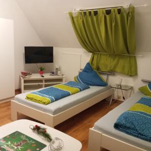 索林根Gäste Monteurzimmer Haus Südstadt的小房间设有两张床和电视