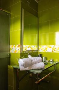 圣罗莎德卡瓦尔Santa bárbara的绿色浴室设有玻璃水槽和毛巾