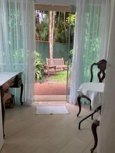 伯迪亚哥Pouso Costa do Sol的客房设有书桌和带长凳的窗户。