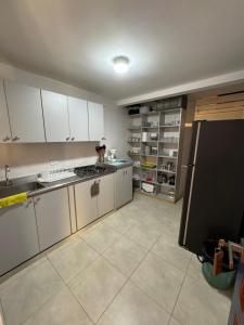蒙特内哥罗Cabaña Quindiana - Excelente Ubicación的厨房配有白色橱柜和黑色冰箱。