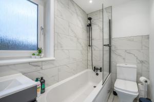阿普海尔Modern 4 Bed House-Free Parking的带浴缸、卫生间和盥洗盆的浴室