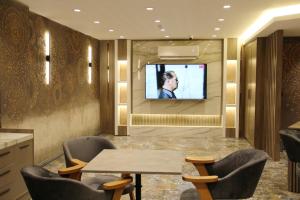 伊斯坦布尔Sabiha Sultan Hotel-Karakoy的配有电视和桌椅的房间