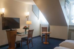 慕尼黑丹尼尔酒店的酒店客房设有一张床和一张带电视的书桌。