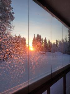 列维Levinlaita的享有雪中日落美景的窗户
