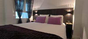 埃尔韦尔赫尔Denia Beach Apartament Jardín privado y piscina的卧室配有一张带紫色枕头的大型白色床。