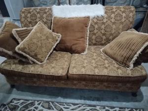 蒙特雷El Nido del Aguila的一张棕色的沙发,上面有枕头
