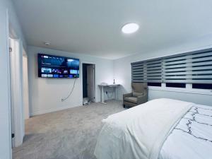 巴里Brand New! Modern Luxury Retreat!的卧室配有一张床,墙上配有电视。
