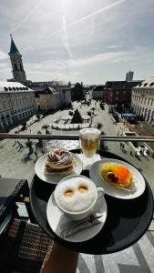 卡尔斯鲁厄埃姆马克特酒店的一张桌子,上面放着两盘食物,享有城市美景