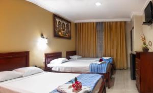 瓜亚基尔Airport Hotel Guayaquil的酒店客房设有三张床和电视。