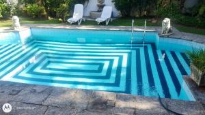 瓜鲁雅Casa aconchegante,perto da praia,com piscina,muito jardim,e pet friendly的水中一个几何设计的游泳池