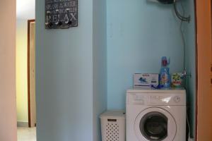 默克斯卡奥姆布拉公寓的洗衣房配有洗衣机和蓝色的墙壁