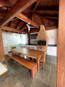 瓜鲁雅Bene Beach - Pousada Guarujá的一间带木桌和壁炉的用餐室