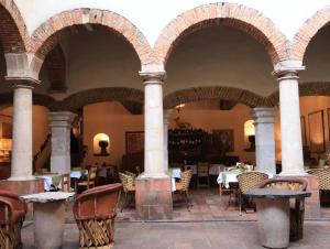 塔斯科·德·阿拉尔孔洛斯阿科斯酒店的餐厅设有拱门和桌椅