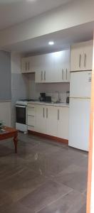 努尔德aruba Villas的厨房配有白色橱柜和白色冰箱。