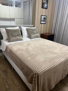 戈亚尼亚Flat aconchegante no Jardim Goias的卧室配有一张带白色床单和枕头的大床。