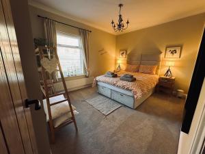 切斯特Overleigh Cottage, with optional Hot Tub hire的卧室配有床、椅子和窗户。