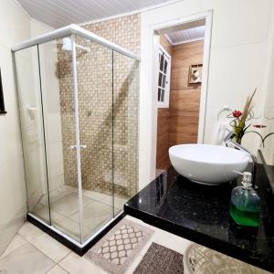特雷索波利斯Hospedagem Doce Lar - Casa Manacá的一间带玻璃淋浴和水槽的浴室