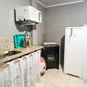 特雷索波利斯Hospedagem Doce Lar - Casa Manacá的厨房配有水槽、微波炉和冰箱