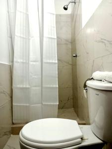 塔拉波托Piccolo Bed & Breakfast的白色的浴室设有卫生间和淋浴。