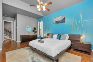 休斯顿Prolific 3Story w Game Room-HotTub-Near DT的一间卧室设有一张蓝色墙壁的大床