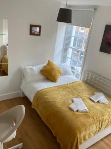 伦敦Private Rooms in Euston, Central London (135)的一间卧室配有一张床,上面有两条毛巾