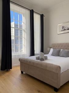 普里茅斯Grand Apartment on HOE/BARBICAN Allocated PARKING!的一间卧室设有一张大床和一个大窗户