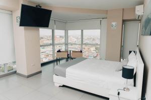 钦博特Hotel Viera Chimbote的一间卧室配有一张床和一台平面电视