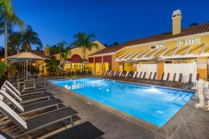 安纳海姆Clementine Hotel & Suites Anaheim的一个带椅子的游泳池和一间酒店
