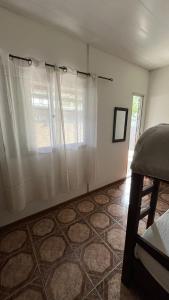 派桑杜Casa cabaña的卧室设有窗户和白色窗帘