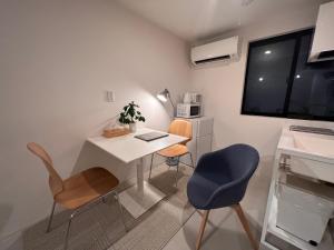 东京Oku-Shibu Residence的小房间设有一张桌子和两把椅子