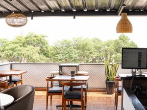 皮乌拉Rua Hoteles Piura的餐厅设有桌椅和大窗户。