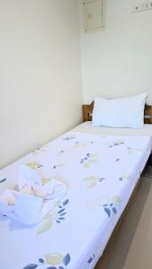 邦劳Charlina Inn Panglao的客房内的白色床,上面有鲜花