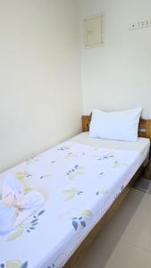 邦劳Charlina Inn Panglao的一张床上铺有白色床单和蓝色鲜花