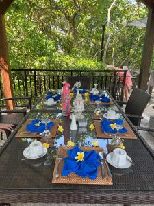 圣吉吉柯本罗汉妮小屋酒店的一张长桌,配有蓝色餐巾和蓝色餐巾